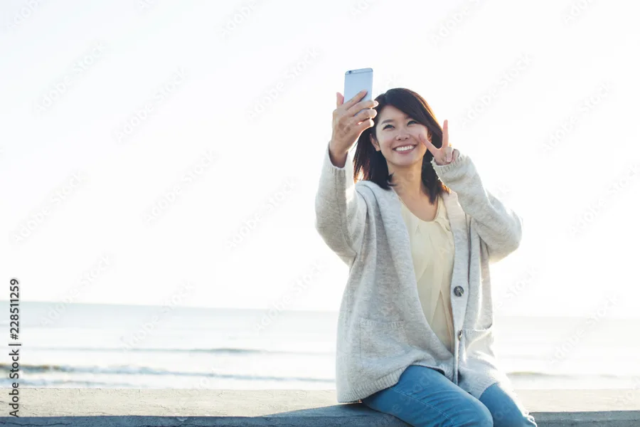 海辺で自撮りするインフルエンサー